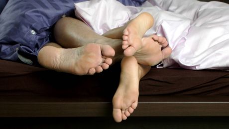 Füße eines im Bett liegenden Paares © imago images/blickwinkel