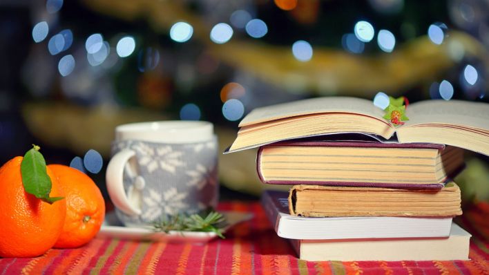 Bücher legen neben einer Tasse und Orangen (Symbolbild) © imago images/Shotshop