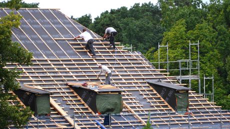 Dachdecker bereiten ein Dach eines Hauses zum Decken vor © radioeins/Chris Melzer