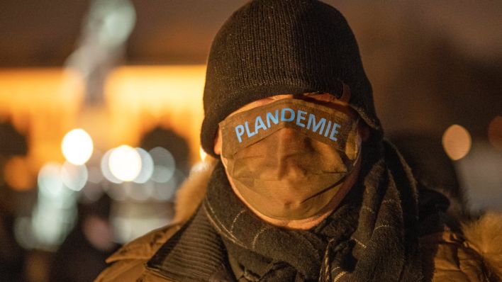 Mundschutz mit dem Wort "Plandemie" bei einem Teilnehmer einer Anti-Corona-Demo