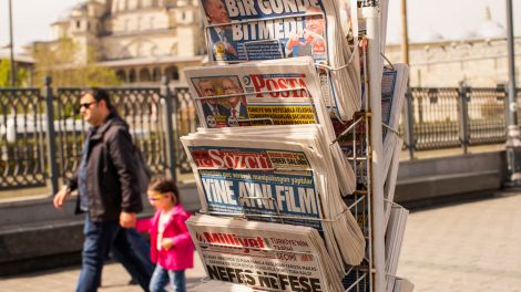 Menschen gehen an einem Zeitungsständer mit türkischen Zeitungen vorbei. © picture alliance/AP/Emrah Gurel