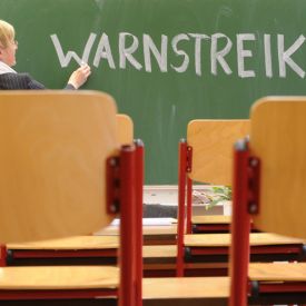 Eine Lehrerin schreibt das Wort "Warnstreik" an die Tafel © picture-alliance/ dpa | Ralf Hirschberger