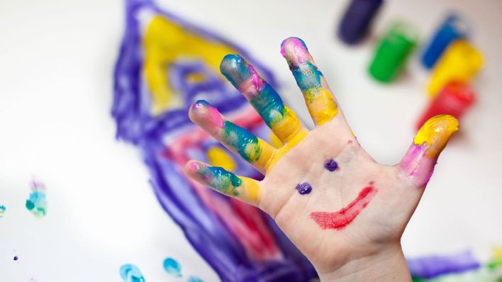 Eine bemalte Kinderhand mit einem glücklichen Gesicht © imago/CHROMORANGE