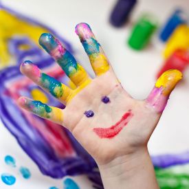 Eine bemalte Kinderhand mit einem glücklichen Gesicht © imago/CHROMORANGE