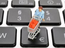 Symbolbild Online-Shopping: Eine Miniaturfigur mit einem Einkaufswagen auf der Tastatur © imago/imagebroker