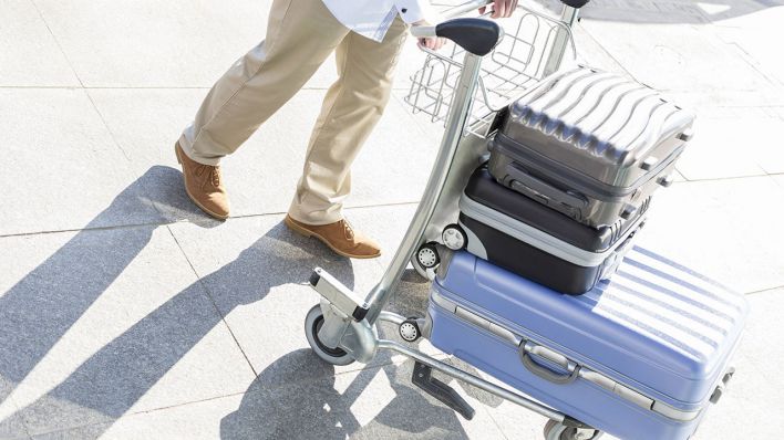 Ein Mann mit seinen gepackten Koffern am Flughafen © imago/Westend61