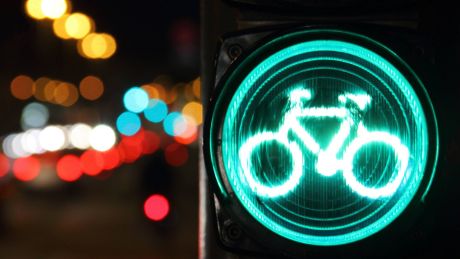 Eine Grüne Fahrradampel bei abendlichem Straßenverkehr in Potsdam
