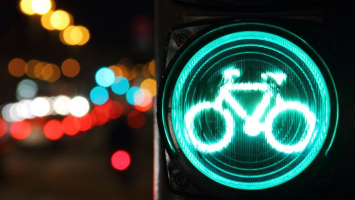 Eine Grüne Fahrradampel bei abendlichem Straßenverkehr in Potsdam