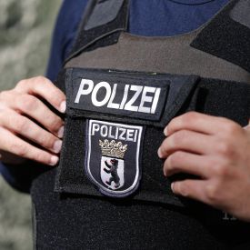 Ein Polizist mit dem Emblem der Berliner Polizei auf der Schutzweste © imago images/Stefan Zeitz
