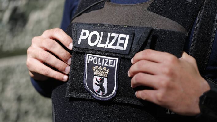 Ein Polizist mit dem Emblem der Berliner Polizei auf der Schutzweste © imago images/Stefan Zeitz