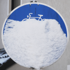 Ein verschneites Verkehrsschild kennzeichnet einen Radweg © imago images/teutopress