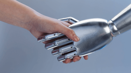 Ein Mensch und ein Roboter geben sich die Hände © imago images/View Stock