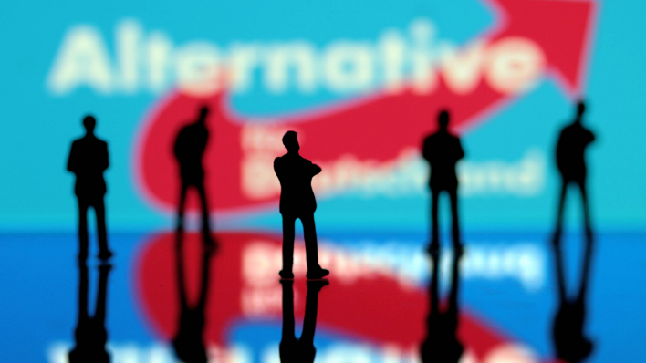 Logo der AfD mit nachdenklichen Miniaturfiguren © imago/Ralph Peters