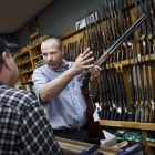 Ein Waffenhändler führt einem Kunden ein Gewehr vor © imago/ZUMA Press