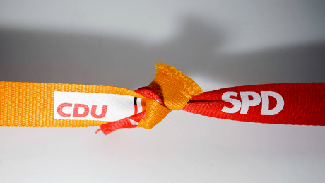 Zwei verknotete Bänder mit den Logos von CDU und SPD © imago/photothek