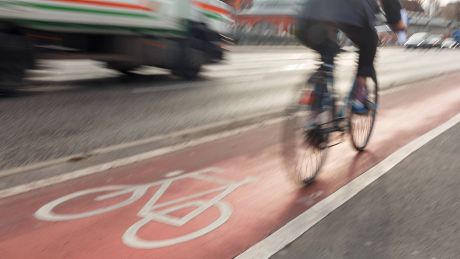 Fahrradfahrer fährt auf einem Radweg und wird von einem Lkw überholt © imago/Marius Schwarz