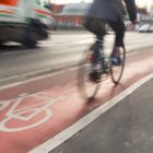 Fahrradfahrer fährt auf einem Radweg und wird von einem Lkw überholt © imago/Marius Schwarz