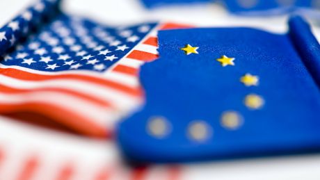 Zerrissene Fahnen von den USA und EU © imago images/Christian Ohde