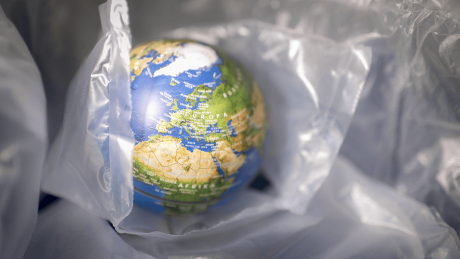 Ein Globus zwischen Plastikverpackungen © imago images/photothek/Ute Grabowsky