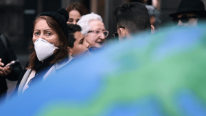 Eine Frau mit einer Schutzmaske © imago images/Matteo Gribaudi