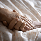 Eine Altenpflegerin hält die Hand einer Frau © imago images/photothek
