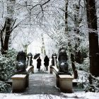 Menschen spazieren durch den verschneiten Tiergarten