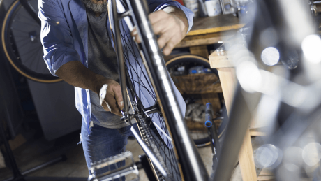Ein Fahrradmechaniker arbeitet an einem Fahrrad in einer Werkstatt © imago images/Westend61
