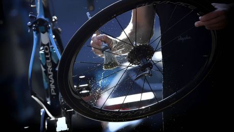 Ein Mann reinigt die Speichen eines Rennradlaufrads