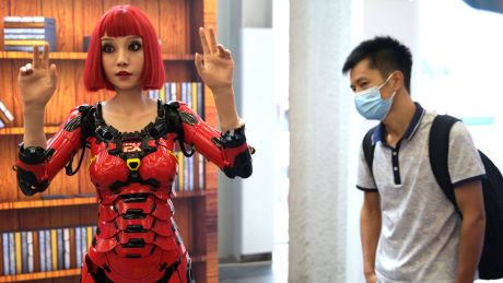 Auf einer Messe in Peking betrachtet ein Besucher einen humanoiden Roboter © imago images/VCG