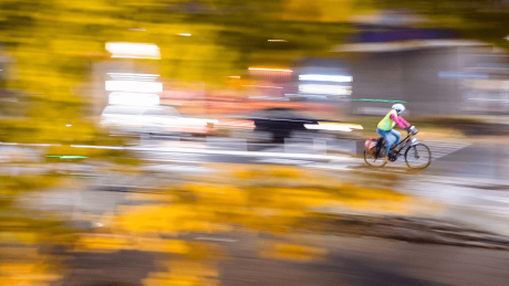 Eine Frau fährt mit einem Fahrrad am frühen Morgen auf einer Straße © dpa/Julian Stratenschulte