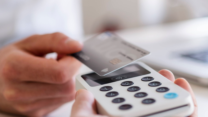 Ein Mann bezahlt mit einer Debitcard © imago images/Westend61
