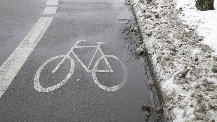 Ein geräumter Fahrradstreifen im Winter