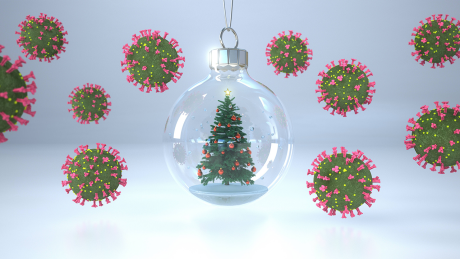 Eine Kugel mit einem Weihnachtsbaum umgeben von Coronaviren (3D-Illustration)