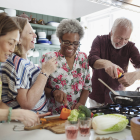Vier ältere Menschen beim gemeinsamen Kochen (Symbolbild)