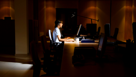 Symbolbild: Eine Frau arbeitet abends in einem Call-Center © imago images/ingimage