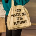 Eine Frau trägt eine Jutetasche mit dem Aufdruck "Your Plastic Bag is so Yesterday" © imago images/Arnulf Hettrich