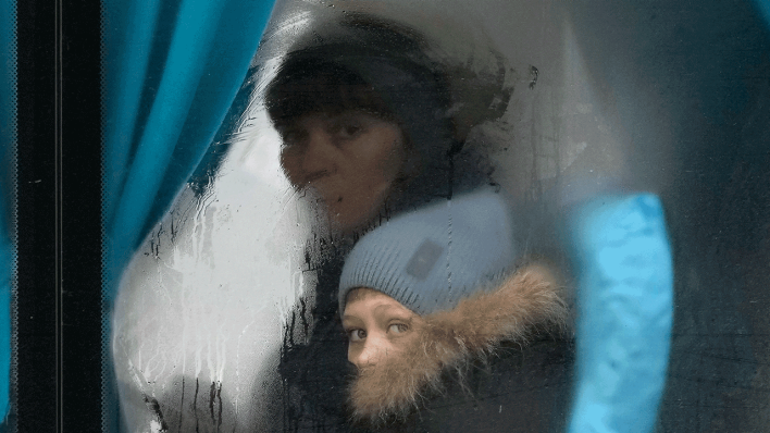 Eine Frau und ein Kind schauen aus dem Fenster eines Busses, als sie Sievierodonetsk in der Region Luhansk in der Ostukraine verlassen.