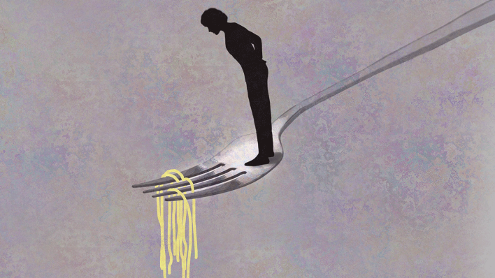 Frau steht auf einer großen Gabel und schaut auf Spaghetti
