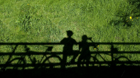 Die Schatten von zwei Radfahrer*innen während einer Pause