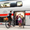 Reisende mit Fahrrädern steigen in einen Zug © IMAGO / Frank Sorge