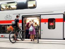 Reisende mit Fahrrädern steigen in einen Zug © IMAGO / Frank Sorge