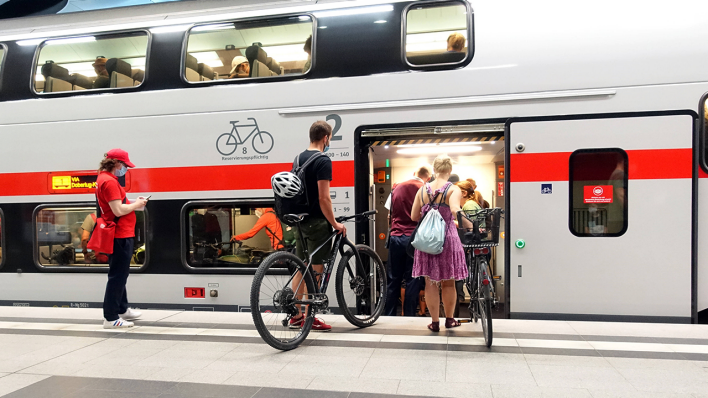 Reisende mit Fahrrädern steigen in einen Zug © IMAGO / Frank Sorge