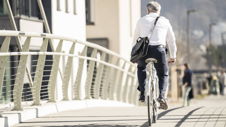 Ein Mann mit Aktentasche fährt auf dem Fahrrad (Symbolbild) © imago images/Westend61