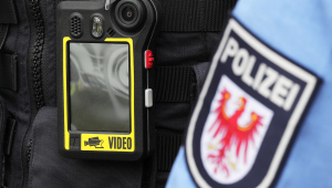 Eine Bodycam ist während eines Pressetermins an der Schutzweste eines Streifenpolizisten befestigt © dpa/Soeren Stache