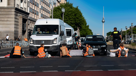Klimaschutz-Demonstrant*innen der Gruppe "Letzte Generation" blockieren im Juni 2022 die Kreuzung am Frankfurter Tor und klebten sich an der Fahrbahn fest. | © dpa/Paul Zinken