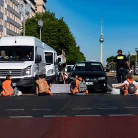 Klimaschutz-Demonstrant*innen der Gruppe "Letzte Generation" blockieren im Juni 2022 die Kreuzung am Frankfurter Tor und klebten sich an der Fahrbahn fest. | © dpa/Paul Zinken
