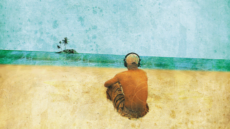 Ein Mann an einem Strand schaut auf eine Insel in der Ferne