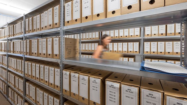 Eine Mitarbeiterin geht durch das Archiv der Stasi-Unterlagen-Behörde © imago images/ari