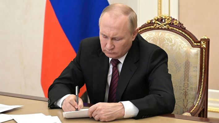 Russlands Präsident Wladimir Putin unterschreibt ein Dokument © imago images/Zuma Wire