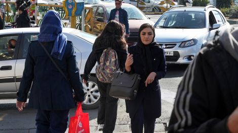 Eine junge iranische Frau überquert in Teheran eine Straße, ohne ihr vorgeschriebenes islamisches Kopftuch zu tragen © AP Photo/Vahid Salemi